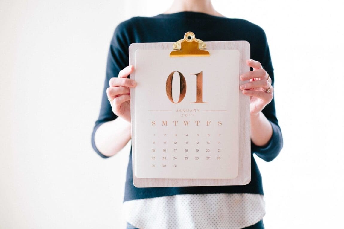 woman holds a calendar open to the month January