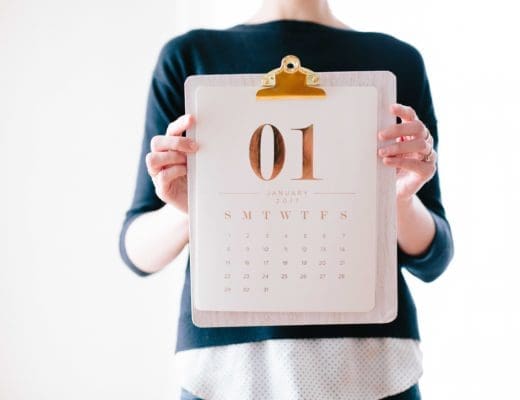 woman holds a calendar open to the month January