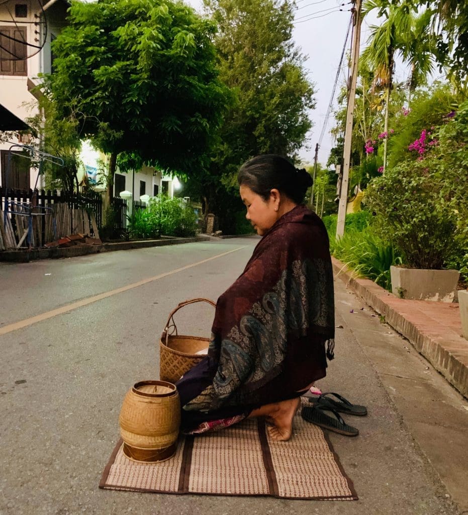 a-woman-prepares-for-tak-bat-ceremony-in-luang-prabang